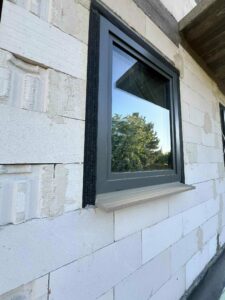 Montaż okna z obustronnym parapetem XPS 700 i zewnętrzną taśmą rozprężną, przygotowanie pod ciepły montaż